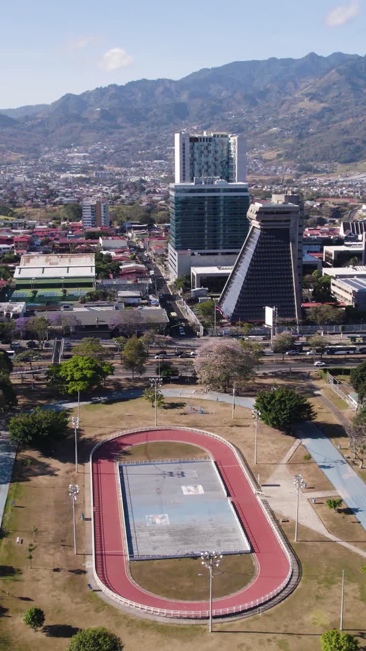 Drone shot overlooking La Sabana Metropolitan Park and surrounding buildings including Republic General Comptroller in San Jose, Costa Rica. Vertical Video