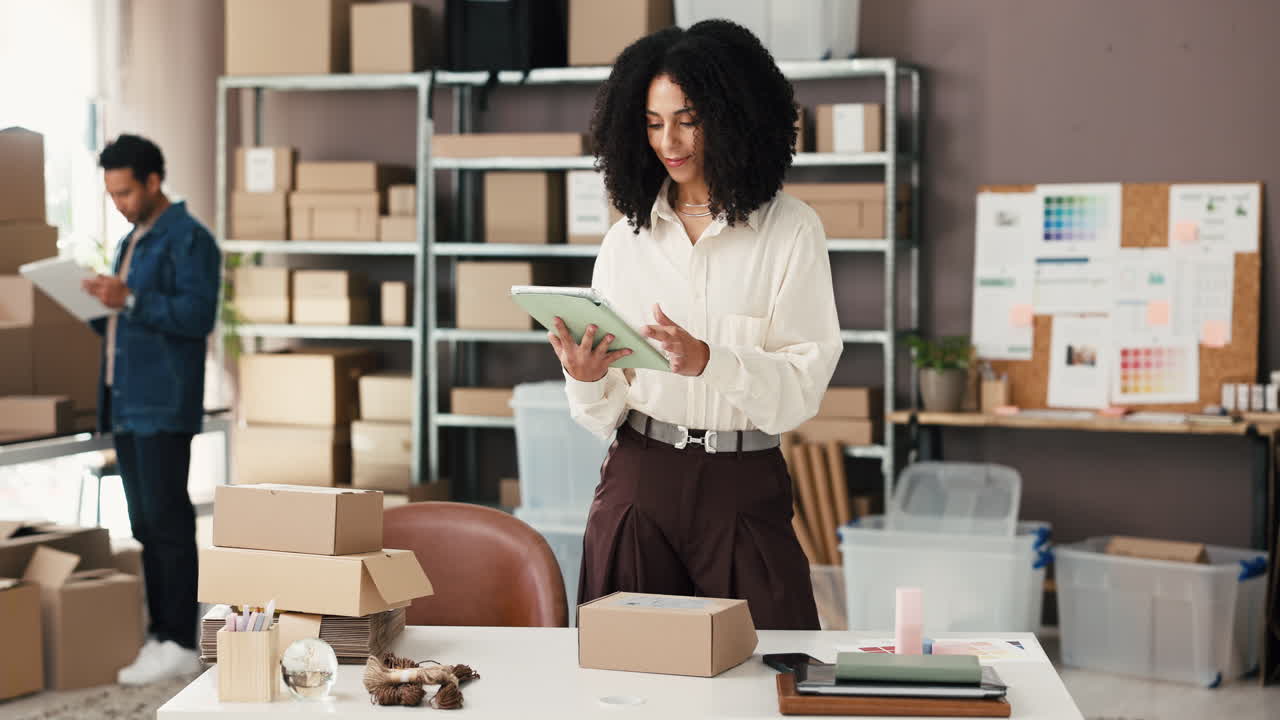 Donna che prepara gli ordini e usa un tablet in un magazzino e-commerce