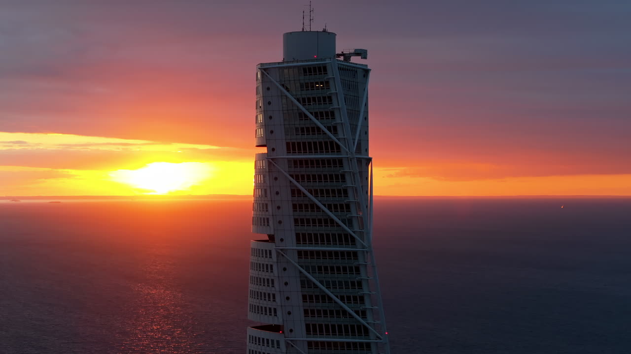 Aerial drone view of Turning Torso residential skyscraper in Malmo, Sweden at sunset