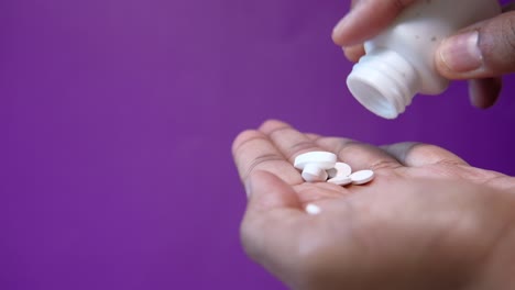 hand pouring pills from a bottle