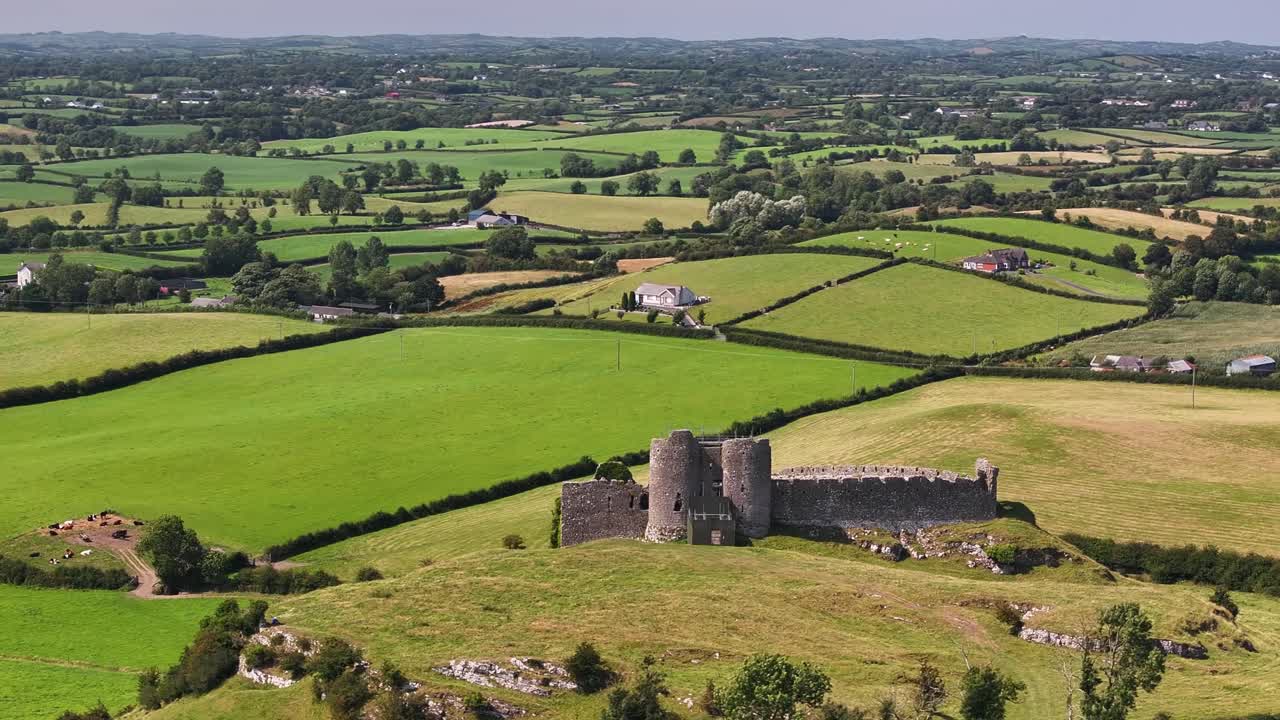 Bellissimo panorama del paesaggio irlandese con il Castello Roche e pascoli verdi all'orizzonte