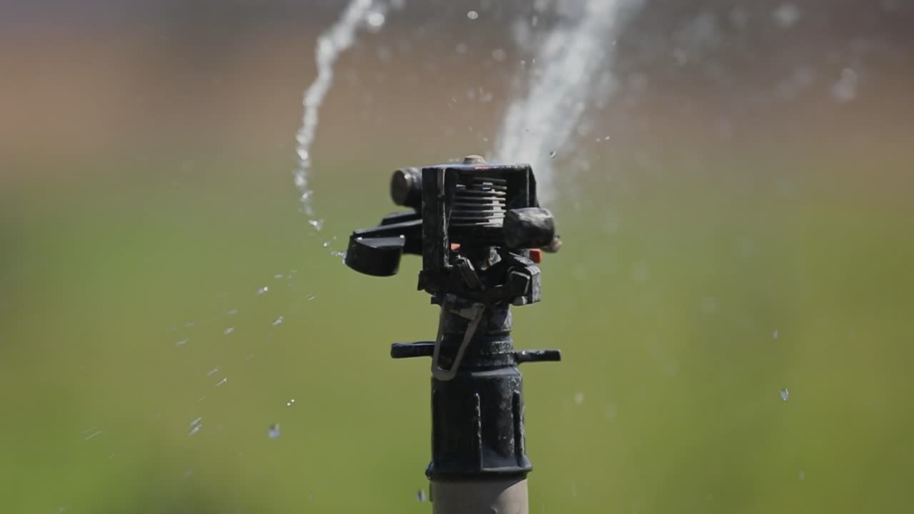 Close-up of Sprinkler System Head Spraying Water to Irrigate Farmland, Sharp Focus 4k