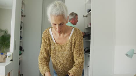 pareja de ancianos caucásicos empacando maletas para viajar