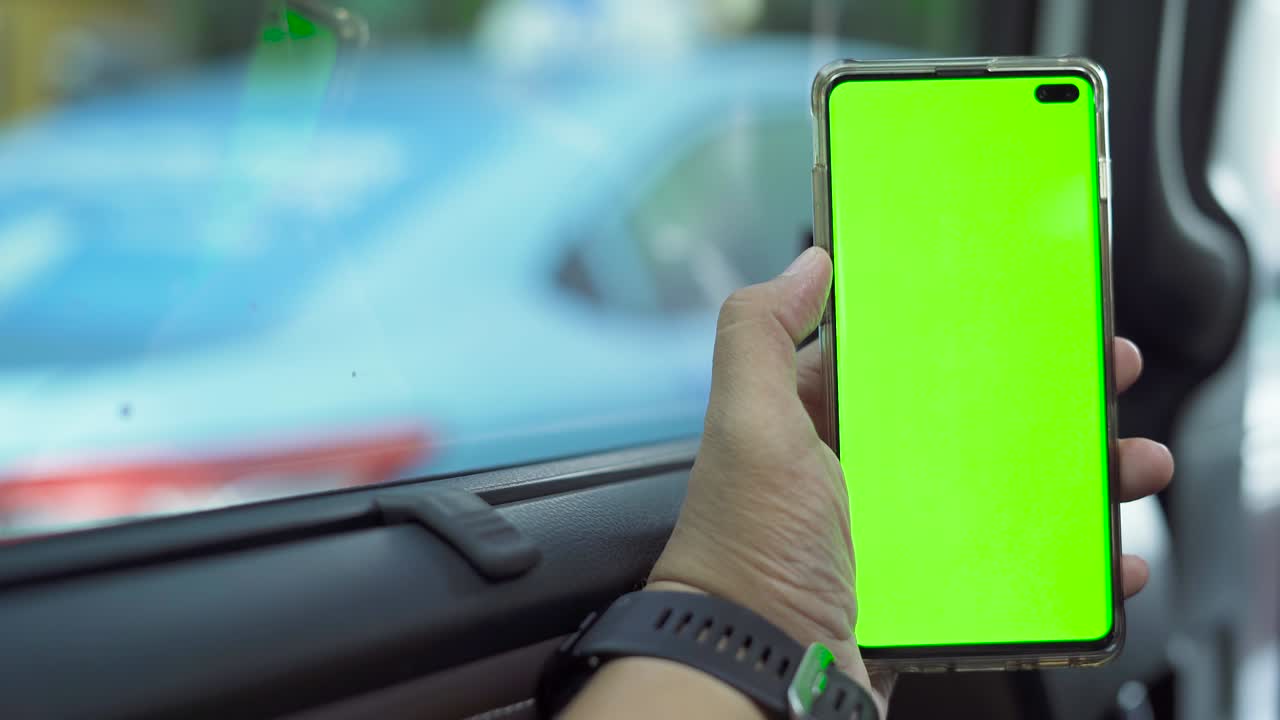 la mano sostiene un teléfono inteligente con una pantalla vacía en el coche