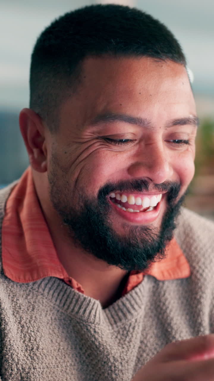 Uomo felice che sorride e guarda in basso in un primo piano.