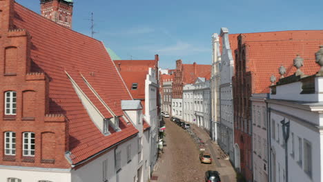 Adelante-Vuelan-A-Través-De-La-Histórica-Calle-Curva-En-El-Centro-De-La-Ciudad-Medieval.-Casas-Antiguas-Con-Hermosas-Y-Cuidadas-Fachadas.-Lübeck,-Schleswig-Holstein,-Alemania