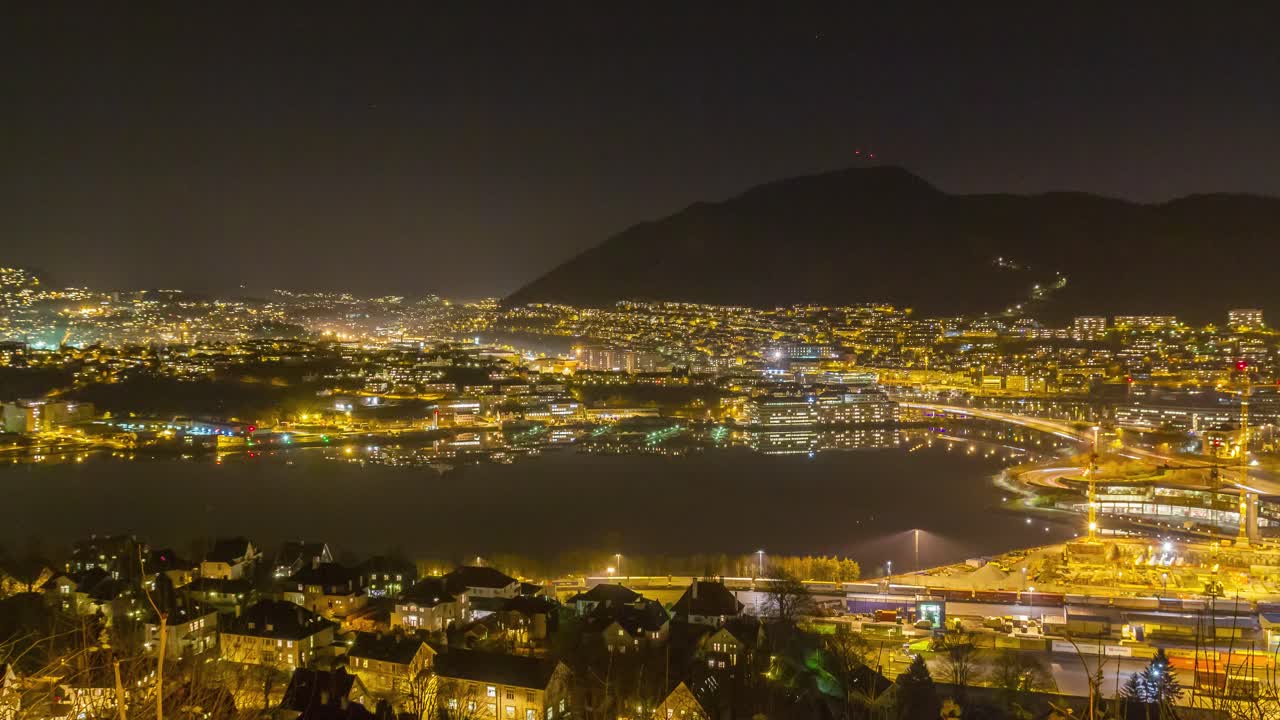 colorida vista nocturna desde kalfaret hacia la plaza danmarksplass y la bahía de solheimsviken en bergen, noruega