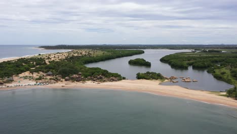 Aerial-descending-over-ocean,-beach-and-waves-in-popular-surfing-destination-of-Arugam-Bay,-Sri-Lanka