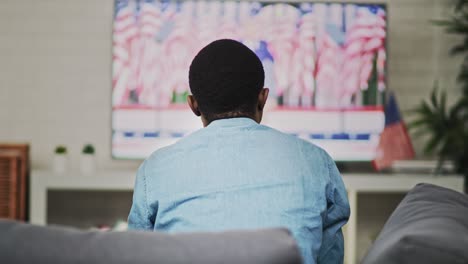 handheld rear view video of man watching tv