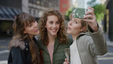 portrait young group of friends taking selfie photo using smartphone mobiel camera technology enjoying fun making faces together in city street background slow motion