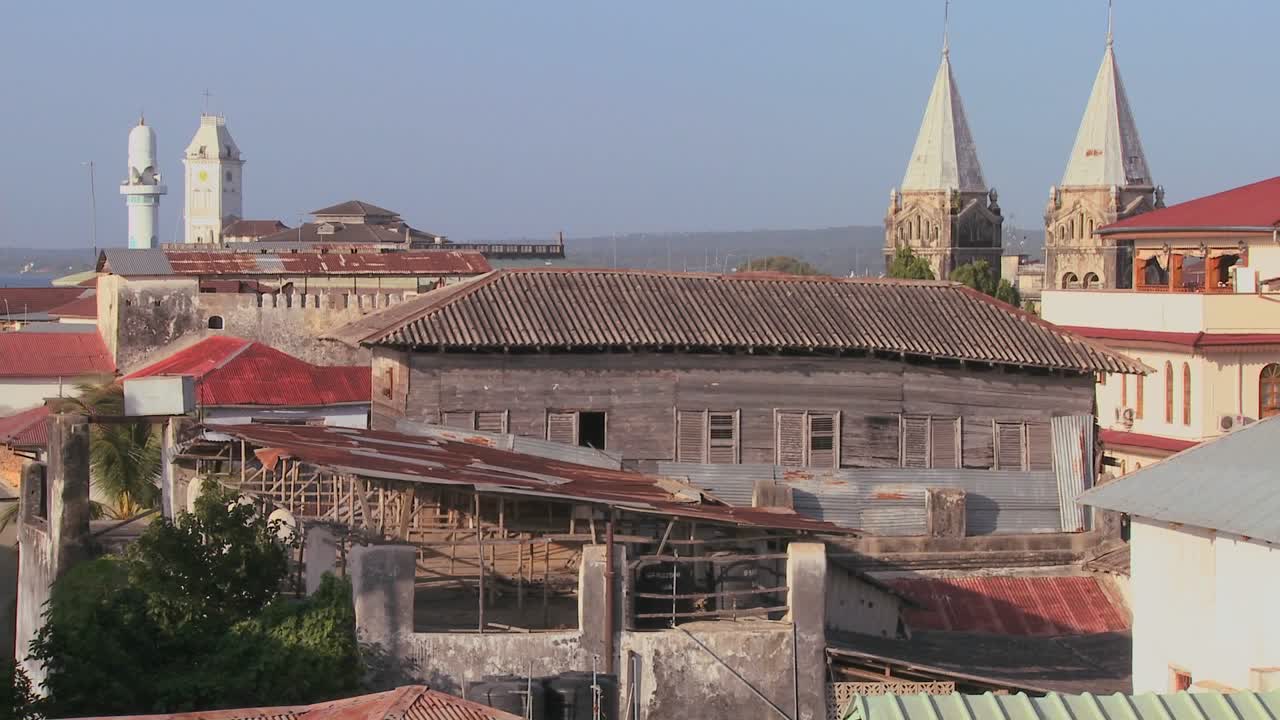 Una panoramica d'insieme dai tetti di Stone Town, Zanzibar, con moschee e campanili di chiesa.