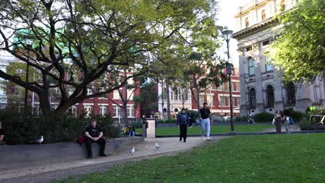 personas caminando y sentadas en un parque