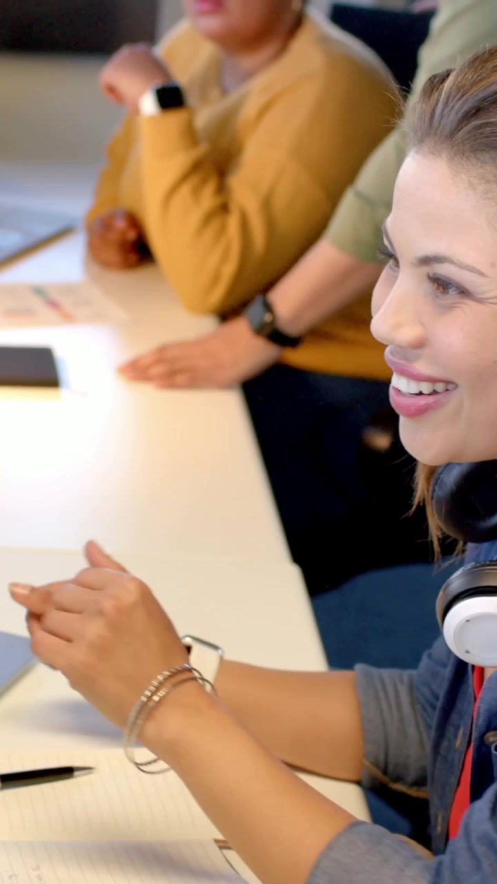 Video verticale: Donna in camicia di jeans che vede i risultati sul monitor, reagisce e rivede dei documenti alla scrivania