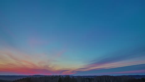 lapso de tiempo de nubes en diferentes colores durante una puesta de sol sobre una reserva natural