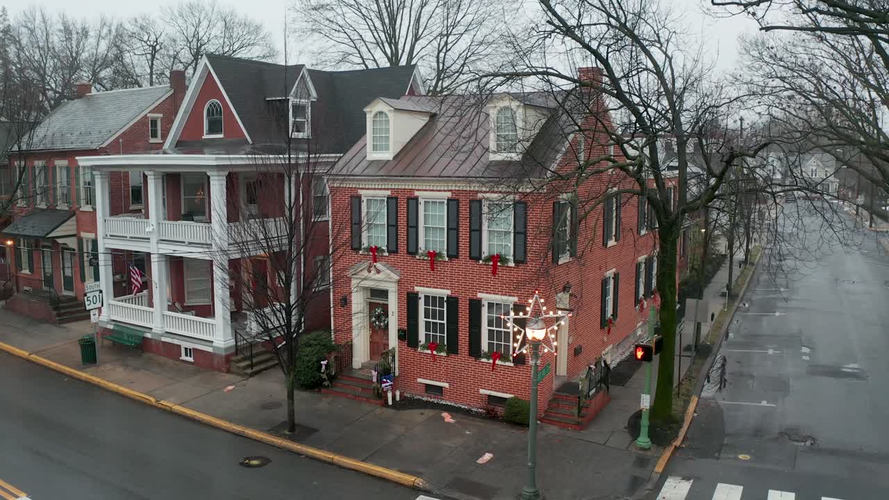 Aerial of restored historic red brick home, decorated for Christmas holiday