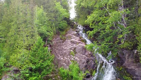 Aerial-footage-of-waterfall-between-trees