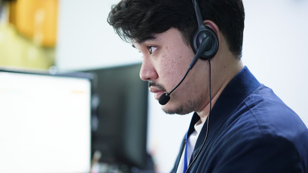 slow motion scene middle eastern adult call center employee man smiling with wear headset while talking with customer in operation office for contact us and telemarketing job concept