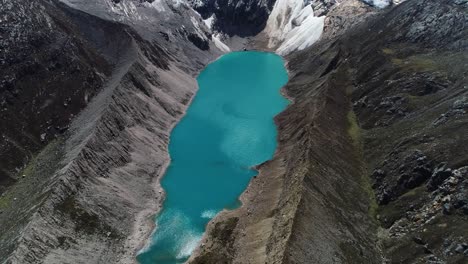 Stunning aerial view of a turquoise glacial lake surrounded by towering Andean mountains. Ideal for nature lovers, travel blogs, and breathtaking landscape video