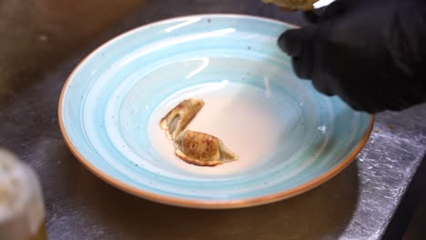 adding pasta stuffed with meat on to a plate in slow motion