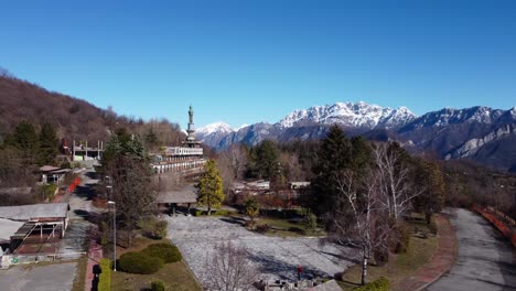 vista aérea sobre la ciudad fantasma de consonno en el municipio de olginate de la provincia de lecco con montañas cubiertas de nieve en el fondo