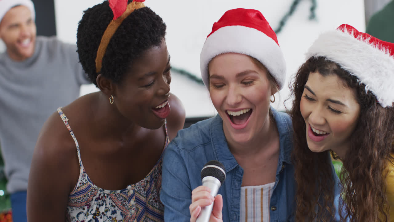 un grupo feliz de amigos diversos cantando karaoke en una fiesta de navidad