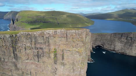 Luftaufnahme-Von-Wanderern-An-Der-Klippe-Des-Traelanipa-Gipfels,-Die-Den-Blick-Auf-Den-Sorvagsvatn-See-über-Dem-Atlantischen-Ozean-Freigibt