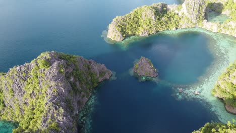 Aerial-seascape-of-rock-islets-and-sunlit-tropical-lagoons,-Coron