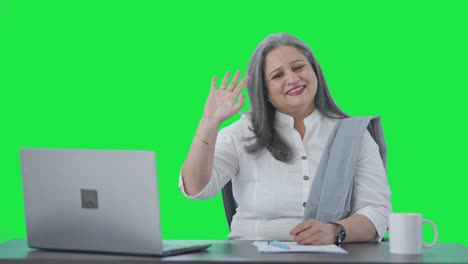 Happy-Indian-senior-businesswoman-waving-and-saying-Hello-Green-screen