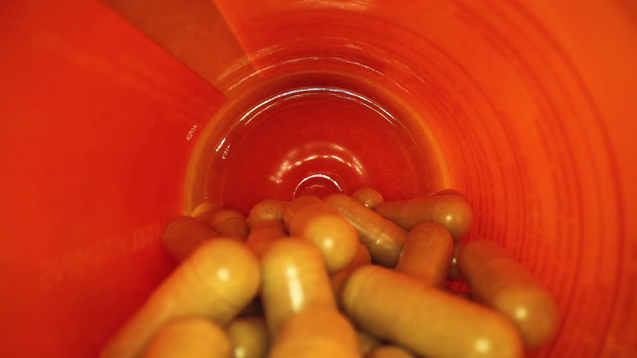 sacando toda la longitud de un frasco de píldoras de suplemento naranja, revelando la tapa del frasco