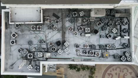 Hochwinkel-Luftaufnahme-Von-Wechselstromventilatoren-Auf-Dem-Dach-Eines-Wohngebäudes-An-Einem-Heißen-Tag,-Drohnenaufnahme-Aus-Der-Vogelperspektive