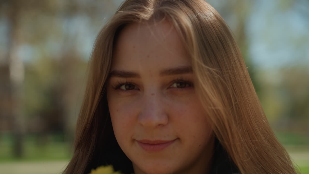 Una joven percibe fragancias florales, una mujer observa dulces aromas florales en la naturaleza, una joven experimenta agradables fragancias de flores que florecen en un entorno natural al aire libre.
