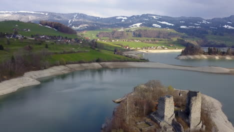 aerial orbit over famous ruins of pont en ogoz fortress on gruyere lake