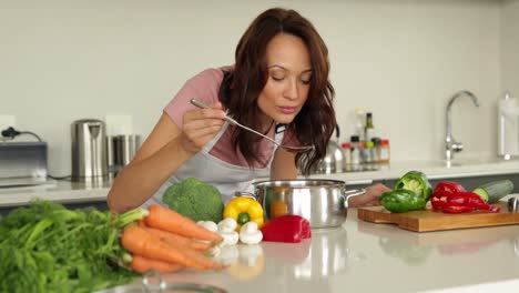 mujer removiendo la sartén con muchas verduras en el mostrador