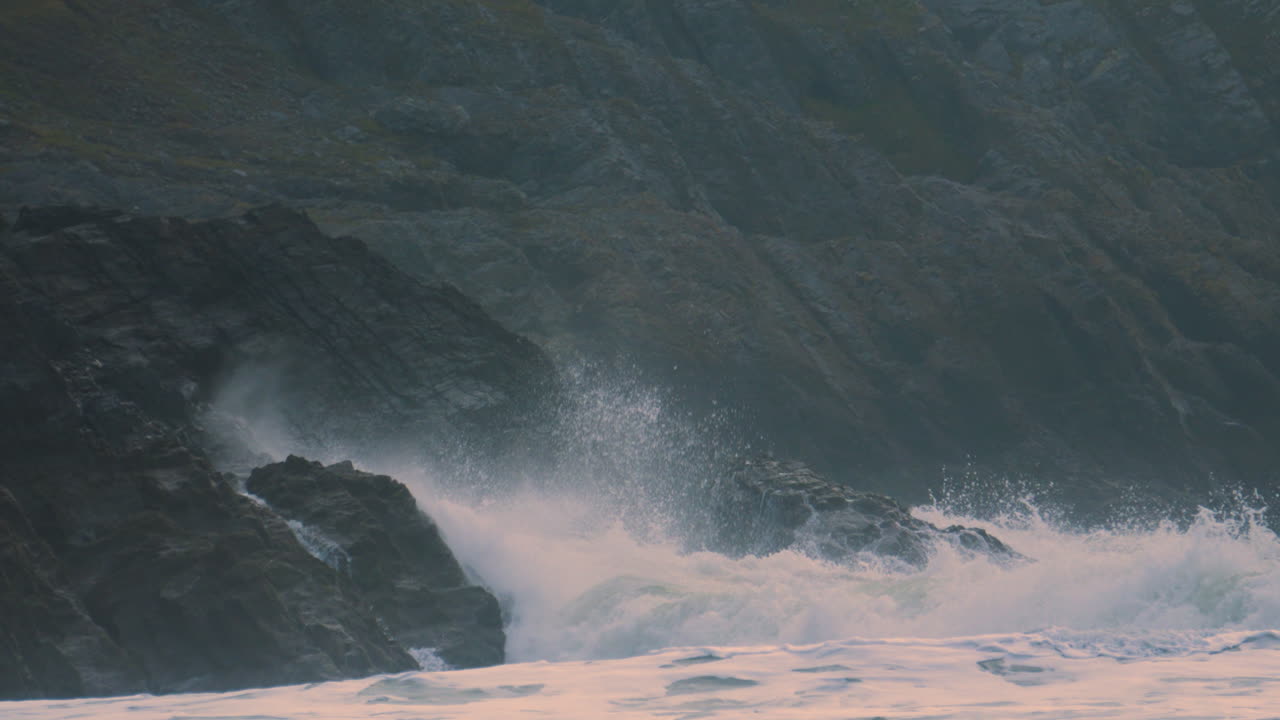 Incredible Dramatic Waves Crashing onto Rocks on Welsh Gower Coast in Slow Motion with Steep Cliffs in Background. Mother Nature Displaying Full Power. ProRes 4K.