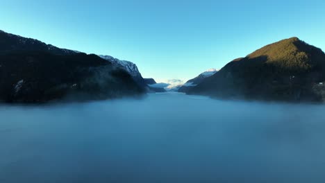 flying into morning fog hovering over norway sea, veafjord in background