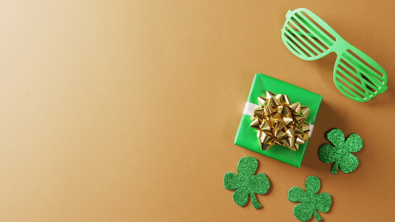 Video di trifoglio verde, regalo e occhiali per il giorno di San Patrizio con spazio per il testo su sfondo arancione
