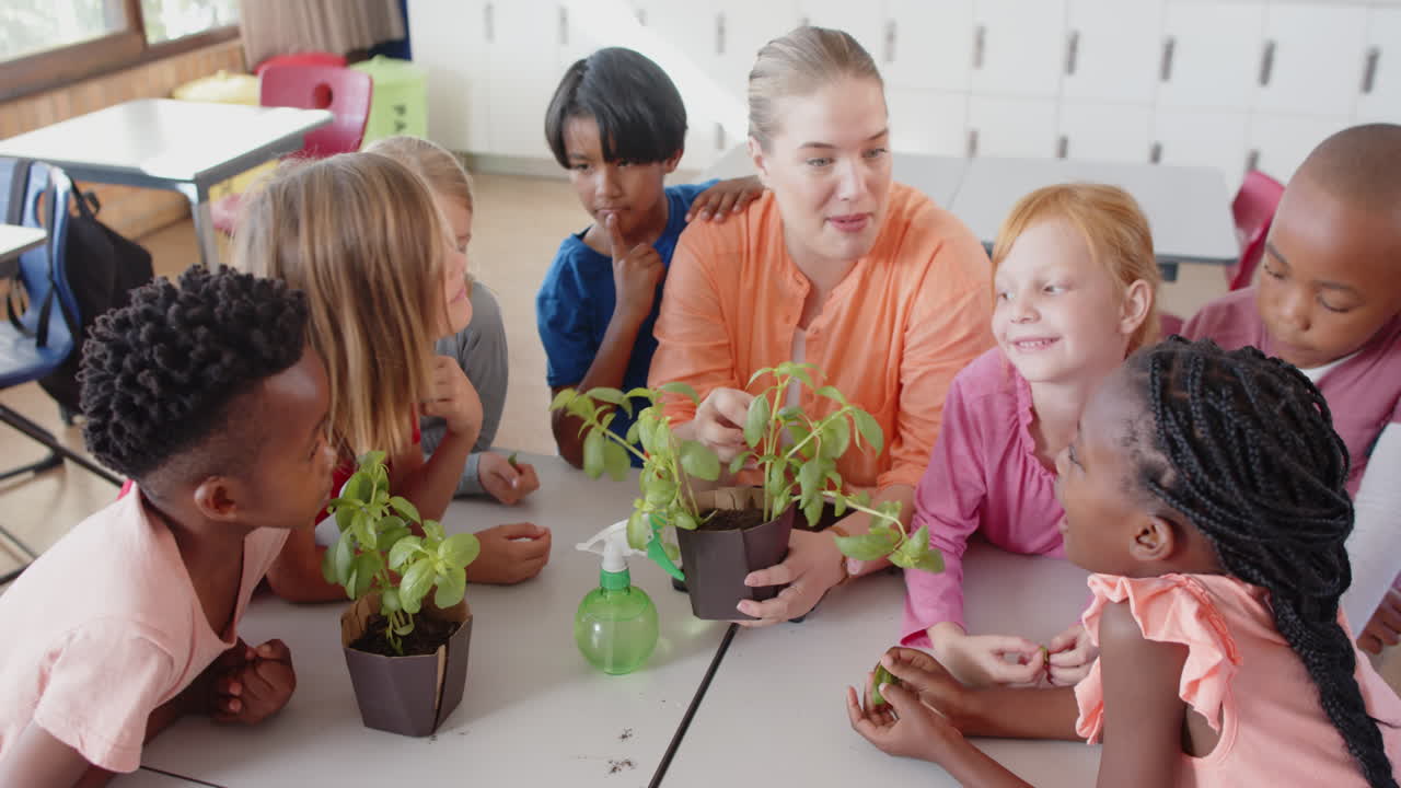 In school, female teacher and students learning about plants and gardening together