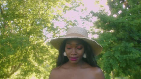 young black woman on picnic in park looking up blows kisses sky tilt