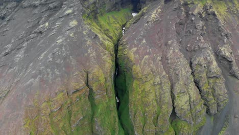 aerial, drone shot tilting towards the raudfeldsgja, the red-cloak rift gorge, on botnsfjall mountain, cloudy day, in snaefellsnes, iceland