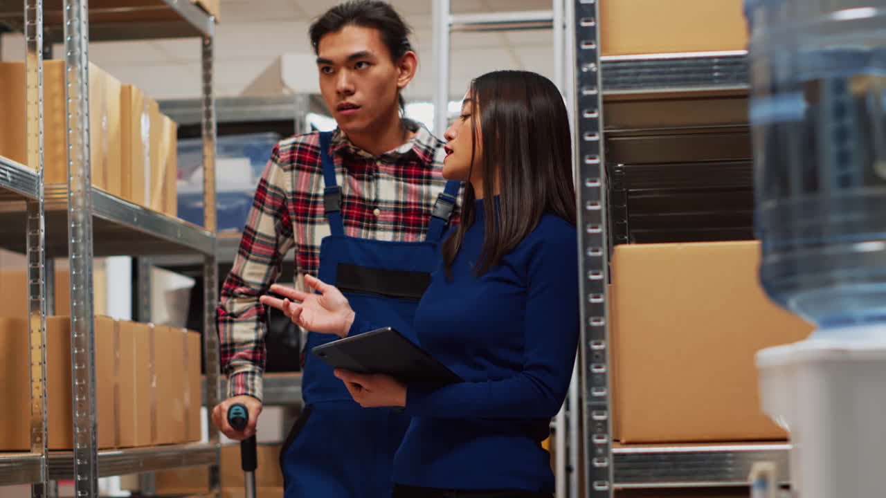 Warehouse workers discussing inventory using a tablet