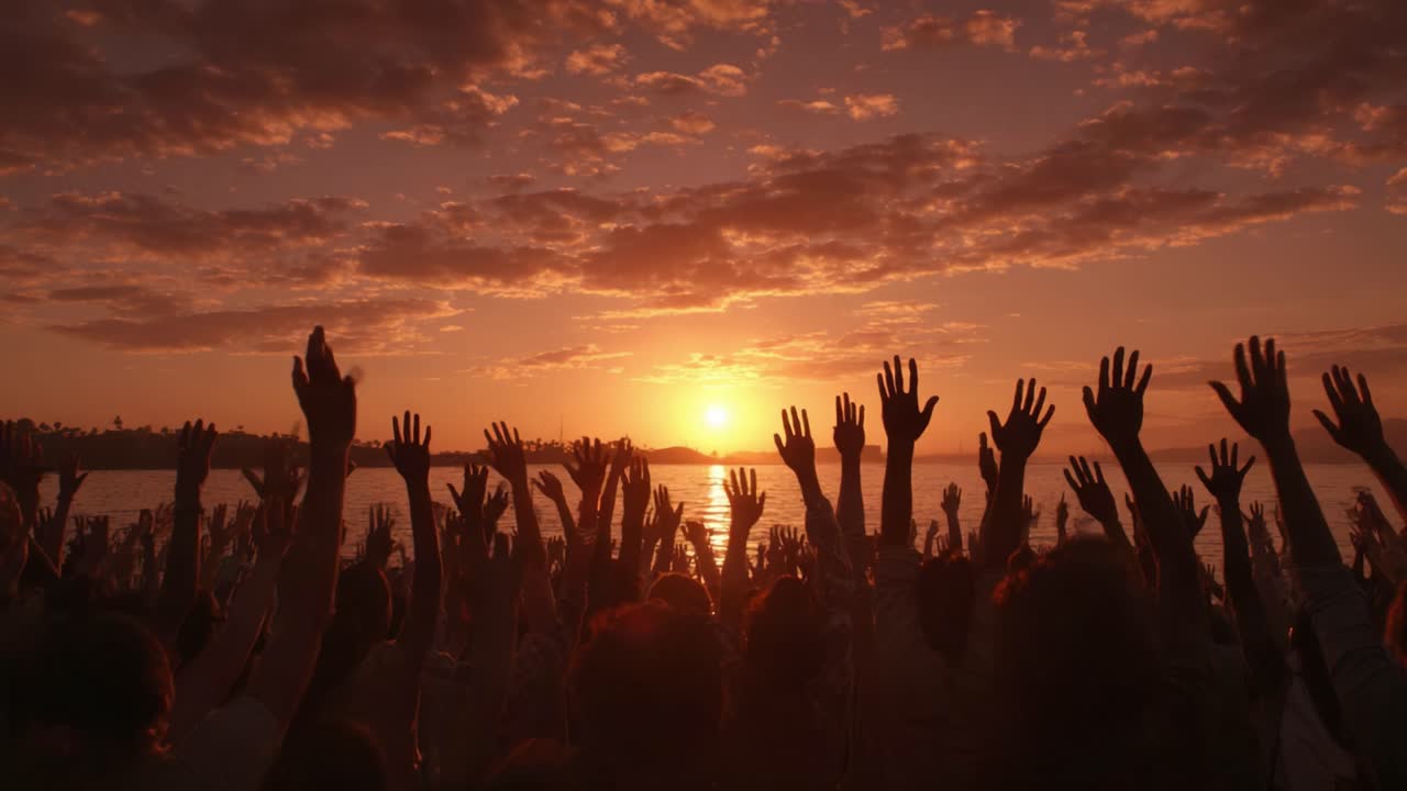A Vibrant Sunset Ceremony: A Community of Joyful Hands Reaching Towards the Evening Sky as the Sun Sets Over the Water, Creating a Beautiful, Inspirational Atmosphere