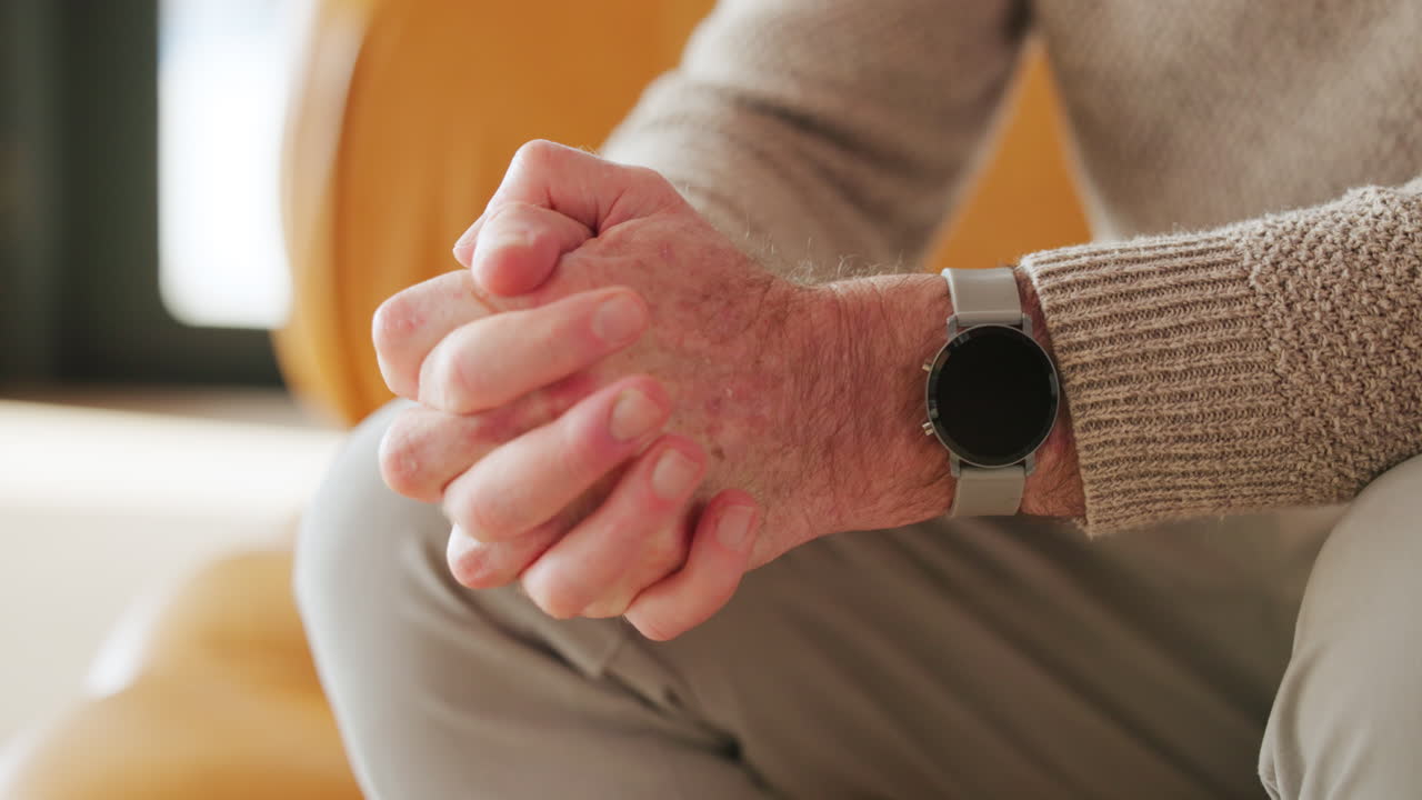 Close-up of Senior Man's Clasped Hands with Smartwatch