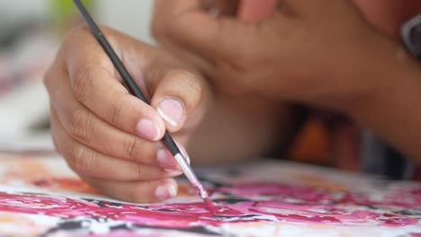 close-up of someone painting with a pink paintbrush