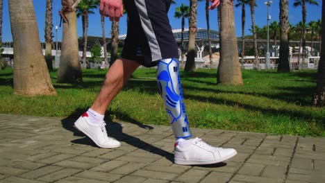 man with prosthetic leg walking in a park