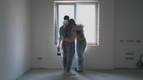 lovely couple looks outside window hugging in renewing room