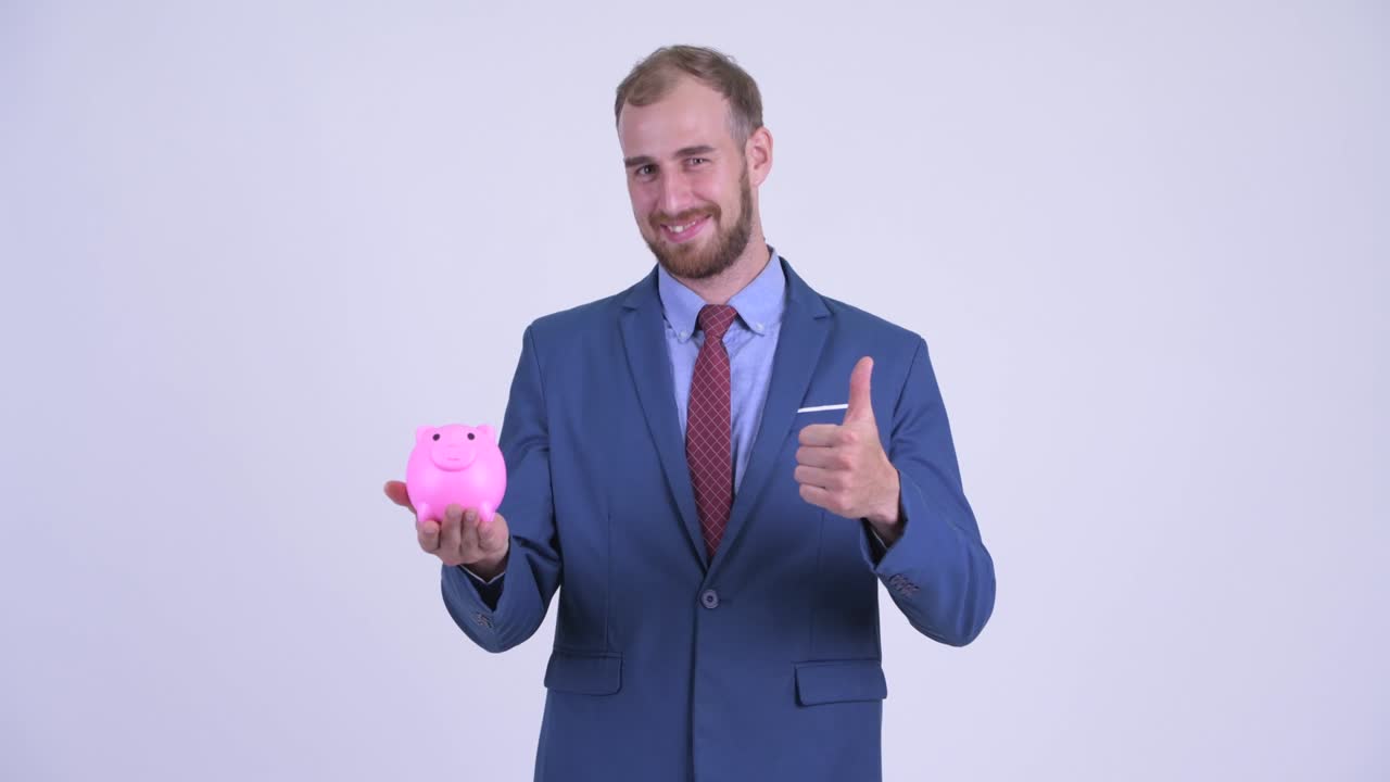 retrato de un feliz hombre de negocios barbudo con una alcancía