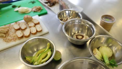 Küchentisch,-Während-Der-Koch-Im-Restaurant-Essen-Zubereitet,-Indem-Er-Salat-Schneidet