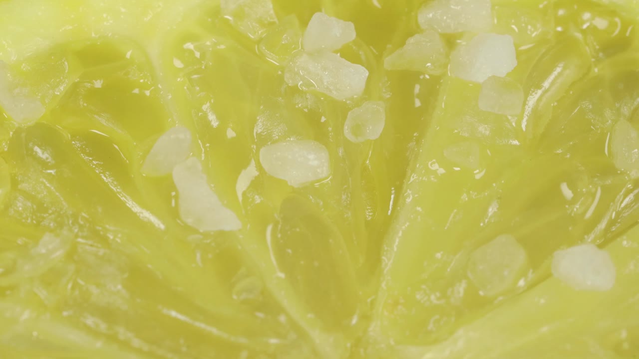 Premium stock video - Lemon macro shot, salt grains falling into it