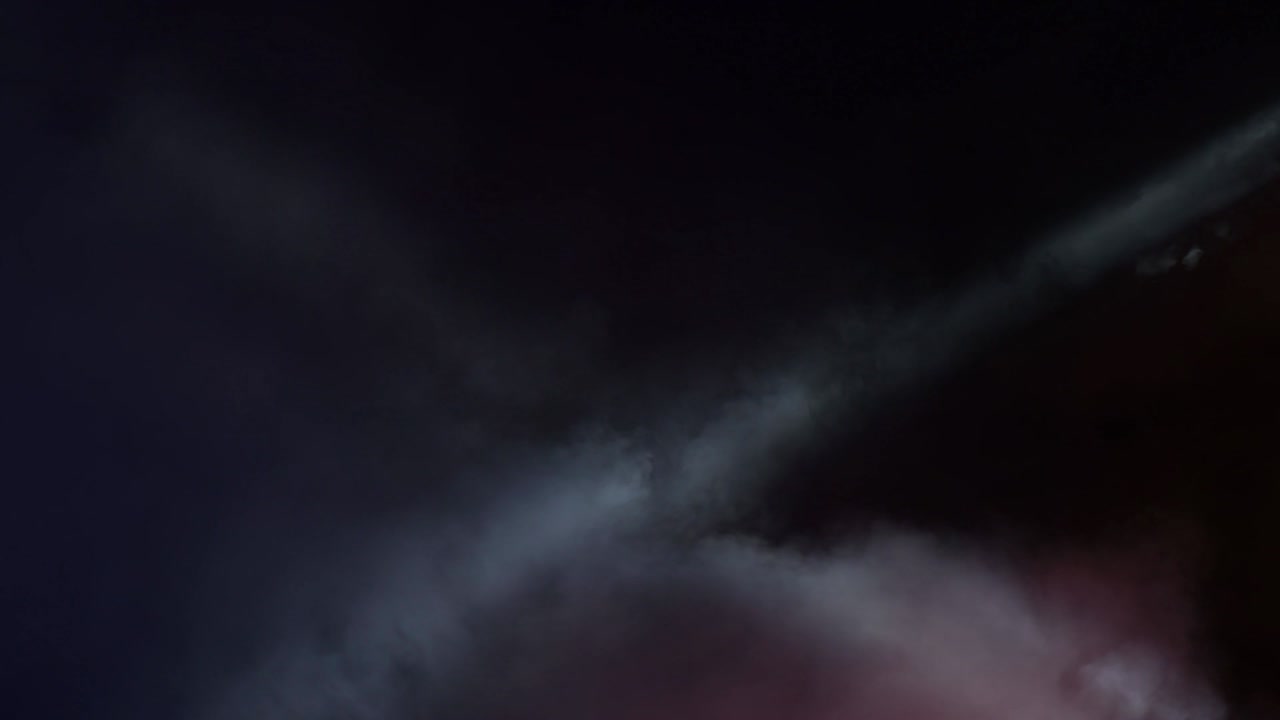 luces cañones y humo moviéndose en el escenario de un concierto