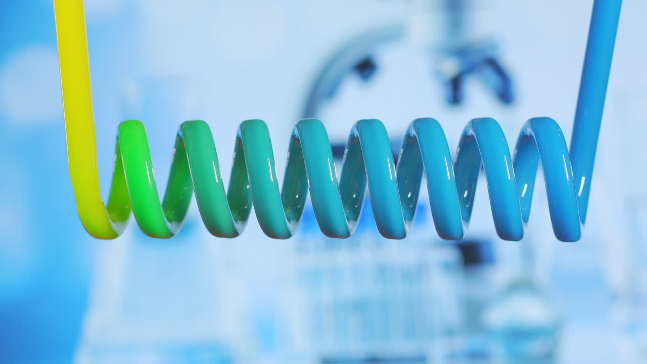 실험실에서 수평 냉장고의 나선형 유리 튜브는 액체의 색을 노란색에서 파란색으로 바니다.